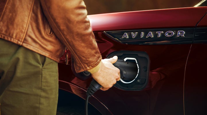 A hand is shown plugging in the charger into the charging port of a 2021 Lincoln Aviator | Angela Krause Lincoln of Alpharetta in Alpharetta GA