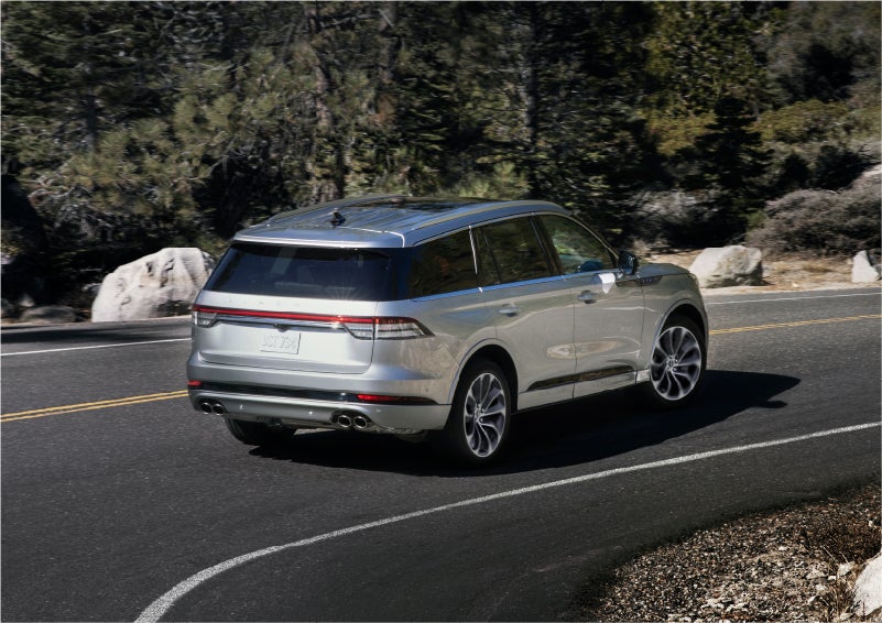 A 2023 Lincoln Aviator® Grand Touring model is shown being driven on a tight turn of a mountain road | Angela Krause Lincoln of Alpharetta in Alpharetta GA