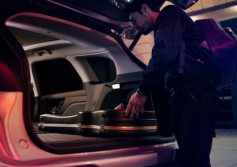 A man is shown loading cargo into the rear of a 2023 Lincoln Corsair® SUV with the second-row seats folded flat. | Angela Krause Lincoln of Alpharetta in Alpharetta GA