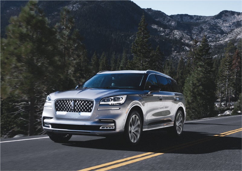 A 2023 Lincoln Aviator® Grand Touring SUV being driven on a winding road to demonstrate the capabilities of all-wheel drive | Angela Krause Lincoln of Alpharetta in Alpharetta GA