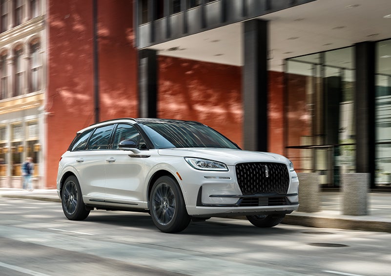 The 2024 Lincoln Corsair® SUV with the Jet Appearance Package and a Pristine White exterior is parked on a city street. | Angela Krause Lincoln of Alpharetta in Alpharetta GA