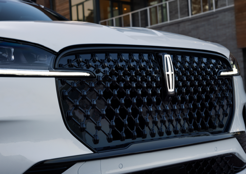 The black grille of a white 2025 Lincoln Aviator® SUV is shown with its fog lights on. | Angela Krause Lincoln of Alpharetta in Alpharetta GA