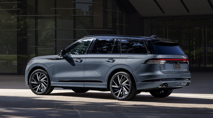 A Whisper Blue 2025 Lincoln Black Label Aviator® SUV is parked outside a modern building. | Angela Krause Lincoln of Alpharetta in Alpharetta GA