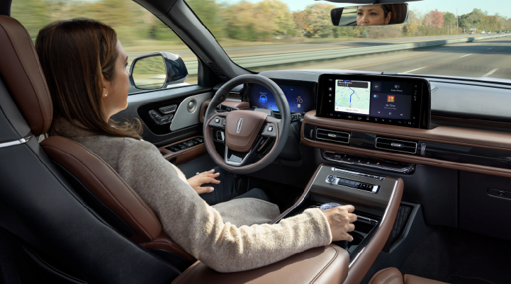A woman is seen sitting in the driver’s seat of her 2025 Lincoln Aviator® SUV with her hands off the steering wheel. | Angela Krause Lincoln of Alpharetta in Alpharetta GA