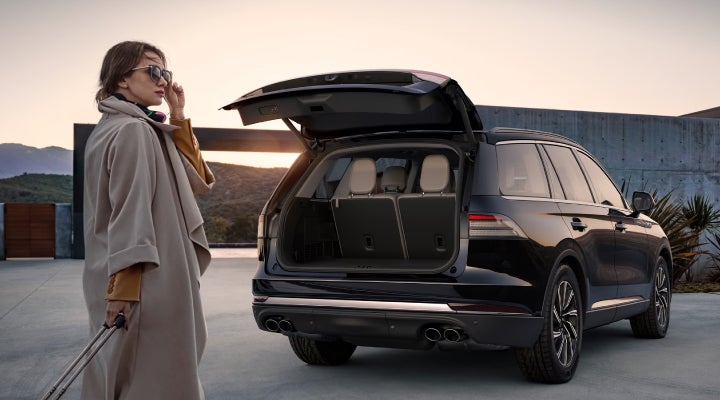 A woman approaches a 2026 Lincoln Aviator® SUV with its rear liftgate open. | Angela Krause Lincoln of Alpharetta in Alpharetta GA