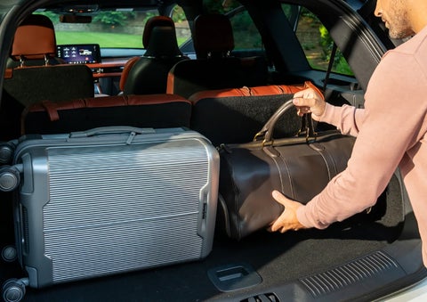 A man loads luggage into the rear of a 2026 Lincoln Aviator® SUV through the opened rear liftgate. | Angela Krause Lincoln of Alpharetta in Alpharetta GA